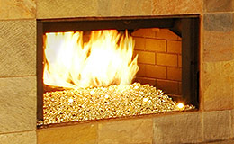 Gold Reflective Nugget Diamond Fire Glass installed in an outdoor fireplace